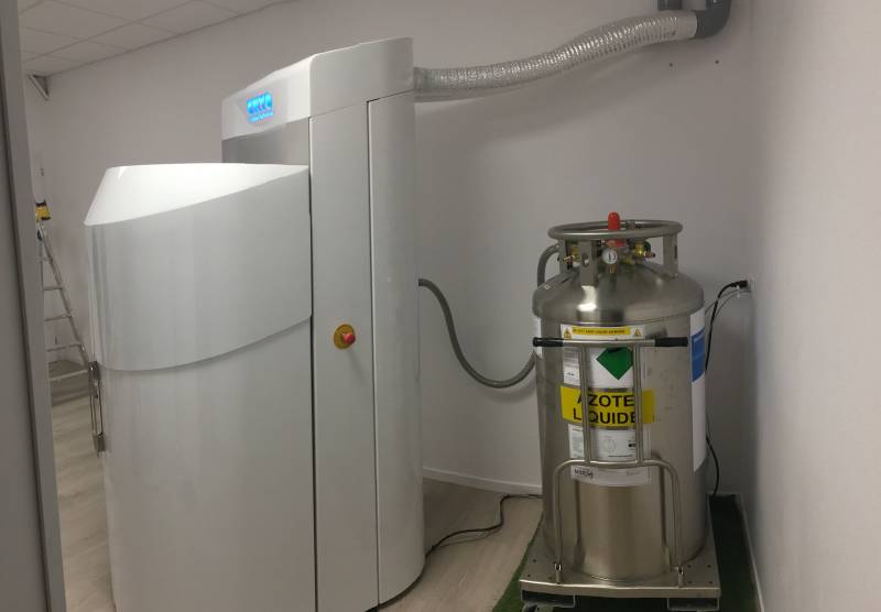 Cuve d'azote pressurisée de 230 litres sur roulette à côté d'une cabine de cryothérapie